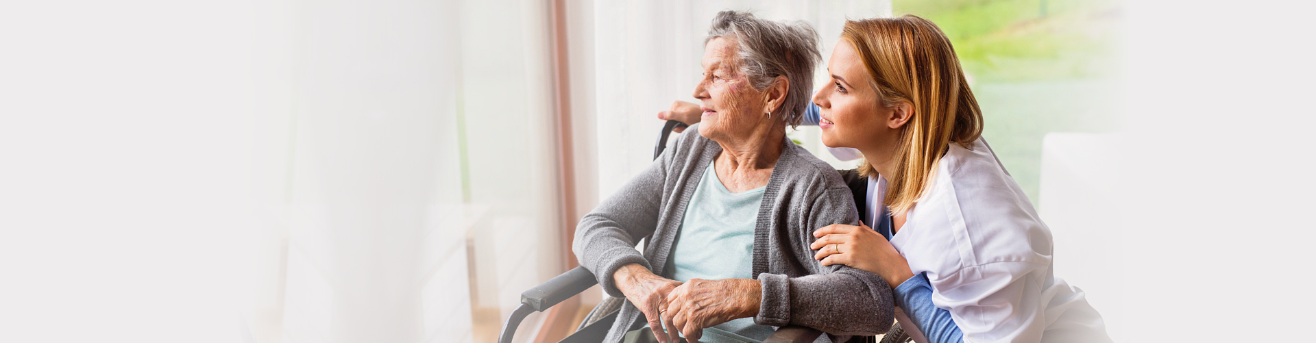 elderly woman in a wheelchair with her caregiver